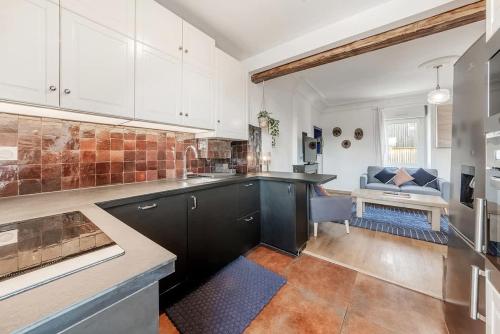 - une cuisine avec des placards noirs et blancs et un canapé dans l'établissement Thabor, beau duplex, 2 chambres, à Rennes