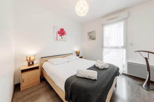 une chambre blanche avec un grand lit et une fenêtre dans l'établissement Le Camélia - Plage et Intra-muros - Parking, à Saint-Malo