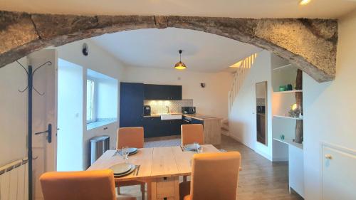 une cuisine et une salle à manger avec une table et des chaises dans l'établissement La Chambonnière, à Chomérac