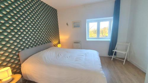 une chambre avec un lit blanc et une fenêtre dans l'établissement La Chambonnière, à Chomérac