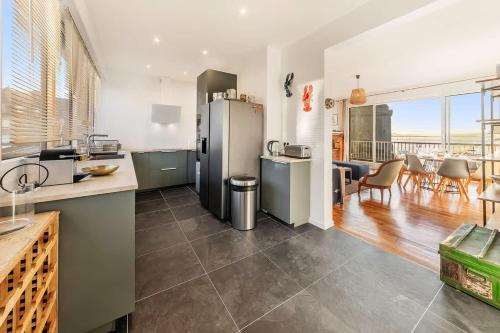 a kitchen with a stainless steel refrigerator and a dining room at Albatros, grand duplex, 4 chambres, vue mer in Saint Malo