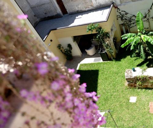 a small garden with purple flowers in the foreground at Sette Fate Suites & Spa in Palermo