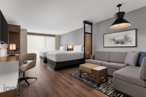 a hotel room with a bed and a living room with a couch at Hyatt Place Mississauga / Airport Corp Center in Mississauga