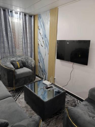a living room with two couches and a flat screen tv at 2A Appartement KDL in Dakar