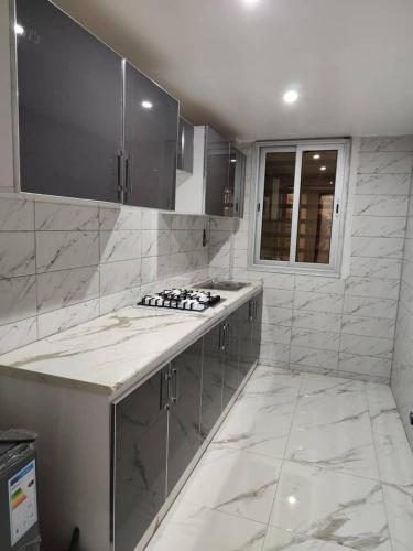 a white kitchen with a sink and a counter at 2A Appartement KDL in Dakar