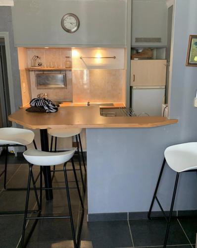 une cuisine avec un comptoir et des tabourets. dans l'établissement A 30 pas de la Plage, à Canet