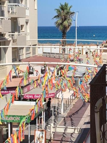 Une rue aux drapeaux colorés et à l'océan dans l'établissement A 30 pas de la Plage, à Canet