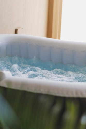 a bath tub filled with water in a room at Villa ElSi, Where Relaxation and Elegance Meet in Valenzano