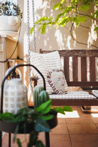 a wooden swing with a pillow sitting on it at Villa ElSi, Where Relaxation and Elegance Meet in Valenzano