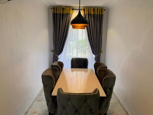d'une table à manger, de chaises et d'une fenêtre. dans l'établissement Funkyndom Apartments, à Lagos