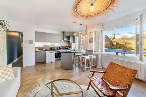 une cuisine et un salon avec une table et des chaises dans l'établissement Le Cerf-Volant, joli 2 chambres, parking, à Saint-Malo