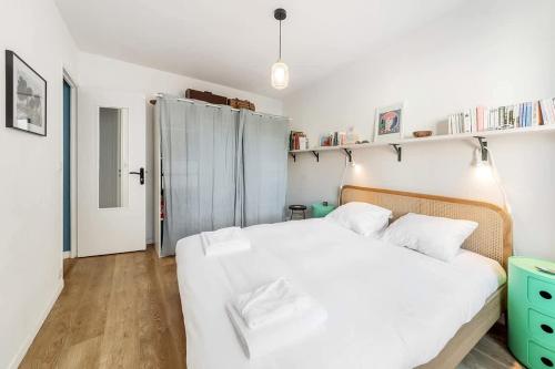 - une chambre avec un lit blanc et des draps blancs dans l'établissement Le Cerf-Volant, joli 2 chambres, parking, à Saint-Malo