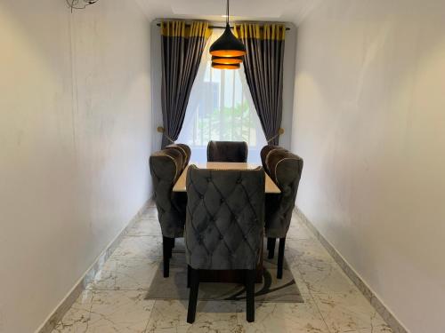 une table à manger avec une chaise et une fenêtre dans l'établissement Funkyndom Apartments, à Lagos