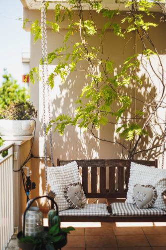 a porch swing with pillows on a patio at Villa ElSi, Where Relaxation and Elegance Meet in Valenzano