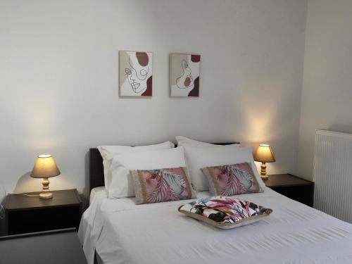 a bedroom with a bed with two tables and two lamps at Tranquil Apartments Corfu in Kontokali