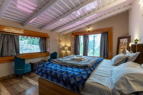 a bedroom with a large bed and two windows at Priory Cottage Heritage Haven in Nainital