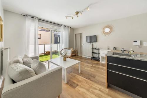 un salon avec un canapé et une table dans l'établissement VAUBAN - Appartement au calme - Parking/Terrasse, à Rennes