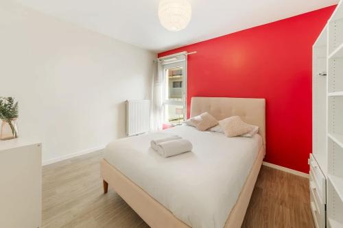 une chambre avec un lit blanc avec un mur rouge dans l'établissement VAUBAN - Appartement au calme - Parking/Terrasse, à Rennes