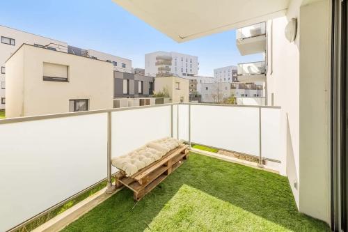 d'un balcon avec un banc sur la pelouse. dans l'établissement VAUBAN - Appartement au calme - Parking/Terrasse, à Rennes