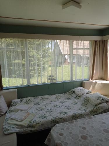 a bedroom with a bed in front of a window at Domek kempingowy Przy Siole Budy in Budy