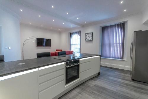a kitchen with a counter top and a refrigerator at Luxury 1 bedroom top floor apartment in Plymouth