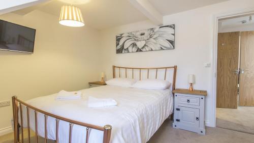 a bedroom with a bed and a tv on a wall at The Crows Nest Apartment in Plymouth