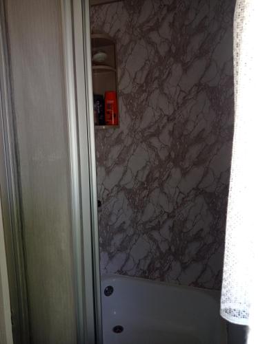 a bathroom with a marble wall at Domek kempingowy Przy Siole Budy in Budy