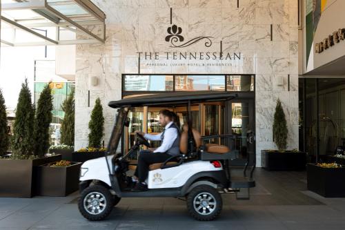 a man riding a golf cart in front of a building at The TENNESSEAN Hotel in Knoxville