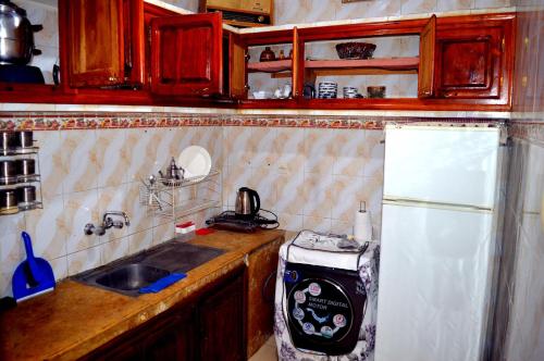 a small kitchen with a sink and a refrigerator at Sunny City Villa with a Garden in Erfoud