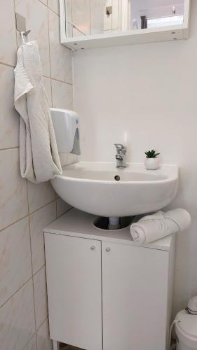 a white bathroom with a sink and a toilet at GoodMo Budapest Smart Rooms in Budapest
