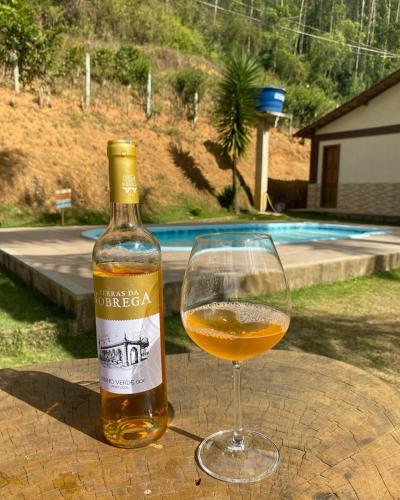 a bottle of wine sitting next to a wine glass at Recanto do Ziu in Santa Teresa