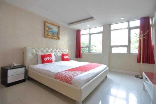 ein Schlafzimmer mit einem großen Bett mit roten Kissen in der Unterkunft OYO Diamond Residence Silom in Bangkok