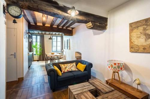 un salon avec un canapé bleu et une table dans l'établissement Le Jacobin, appartement de standing - Hyper centre, à Rennes