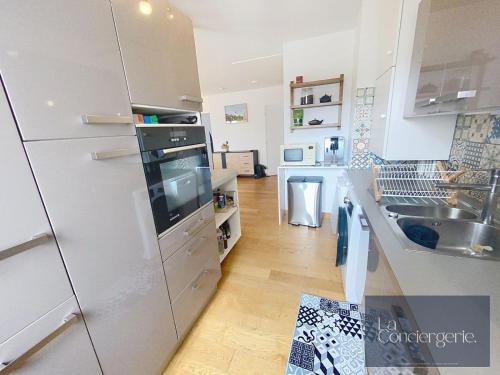 La cuisine est équipée d'un réfrigérateur et d'un évier. dans l'établissement Le Belvédère #28-La Conciergerie - Poitiers centre, à Poitiers