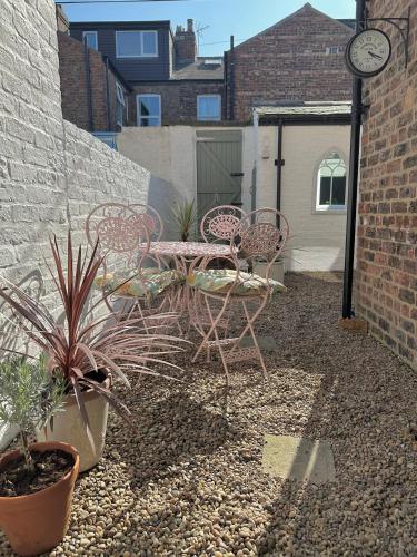 a patio with chairs and a table and a clock at City Apartments - 66 Scott Street in York
