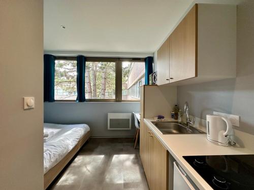 une petite cuisine avec un lit et un évier dans l'établissement Studio 73 Rénové et Équipé - Nancy CHRU,CESI,FAC, à Vandœuvre-lès-Nancy