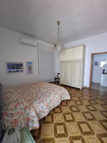 a bedroom with a bed and a tiled floor at Domo de Logu ORIZONTE CÒRSICA in Santa Teresa Gallura