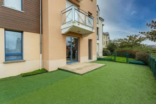a house with a balcony on the side of it at L'Opale - Joli appartement avec jardin et garage in Dinard