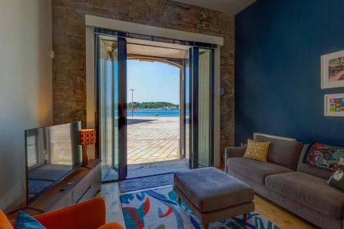 a living room with a couch and a sliding glass door at 5 Brewhouse by Pureserviced in Plymouth