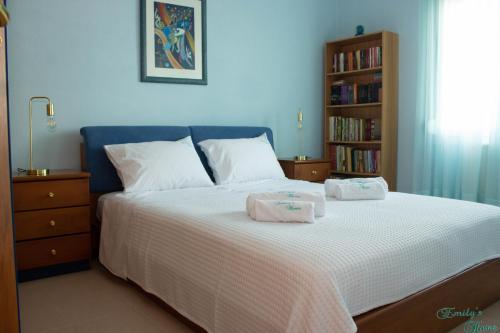 a bedroom with a bed with two towels on it at Emily's Home in Epanomi