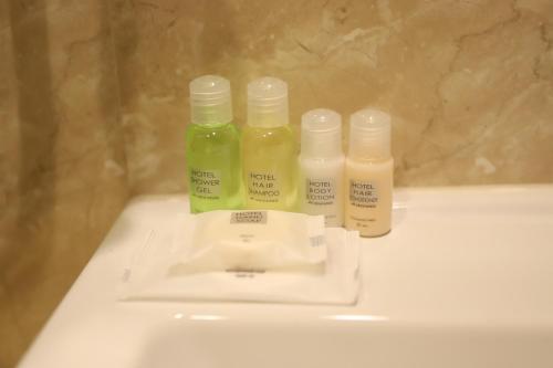 three bottles of moisturizers sitting on top of a sink at Sapsan in Ternopilʼ