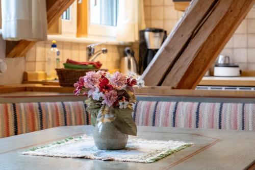a vase of flowers on a table in a kitchen at Gasthaus Heiligenbrunnen in Titisee-Neustadt
