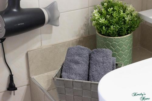 a bathroom with a basket of towels and a plant at Emily's Home in Epanomi