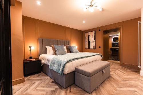 a bedroom with a large bed and a chair at Luxury Georgian Aparthotel by Hauss Ayr - 5mins to Beach, Town Centre! in Ayr