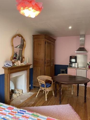 un salon avec une table et une cheminée dans l'établissement Studio cocon centre historique, à Dinan