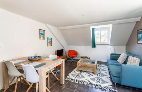 un salon avec une table et un canapé bleu dans l'établissement Le George V - Beau 2 chambres - Coeur de St Servan, à Saint-Malo