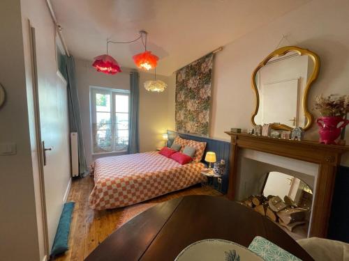 - une chambre avec un lit, un miroir et une cheminée dans l'établissement Studio cocon centre historique, à Dinan