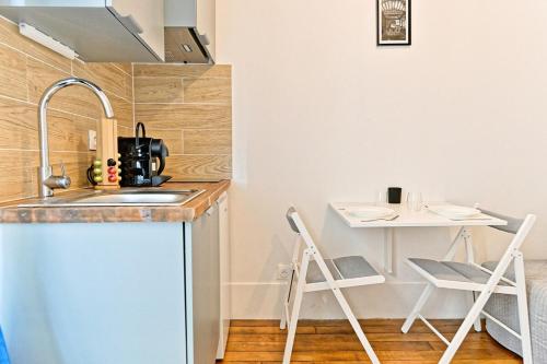 une petite cuisine avec un évier et une table dans l'établissement Studio équipé dans le 18ème arrondissement, à Paris
