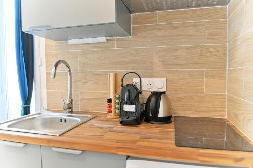 un comptoir de cuisine avec un évier et un micro-ondes dans l'établissement Studio équipé dans le 18ème arrondissement, à Paris