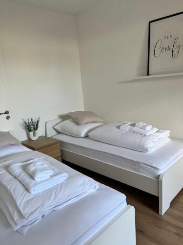 two beds in a white room with white sheets at Q Apartment No 3 in BS - stadtnah im Grünen wohnen in Braunschweig